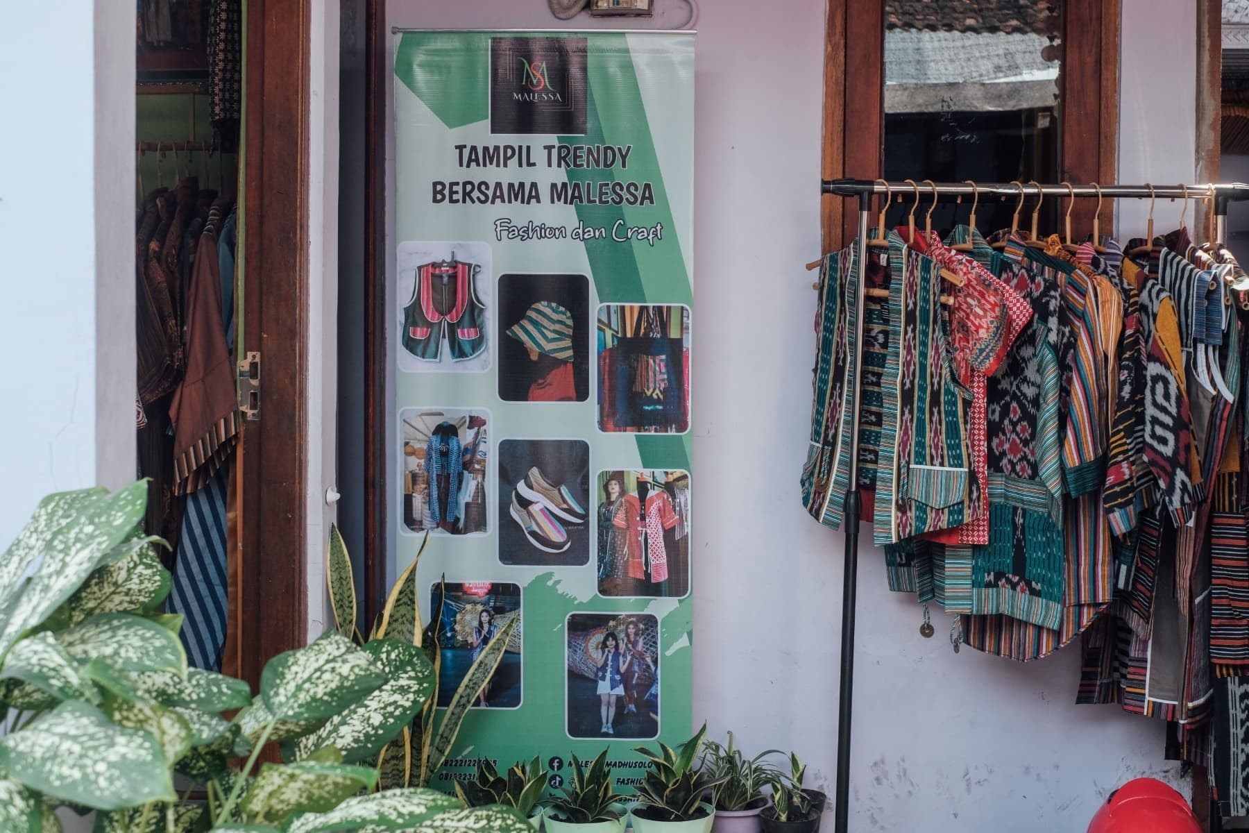 Foto spanduk Malessa Fashion dan kerajinan dengan deretan pakaian bermotif batik perca dipajang di depan toko.