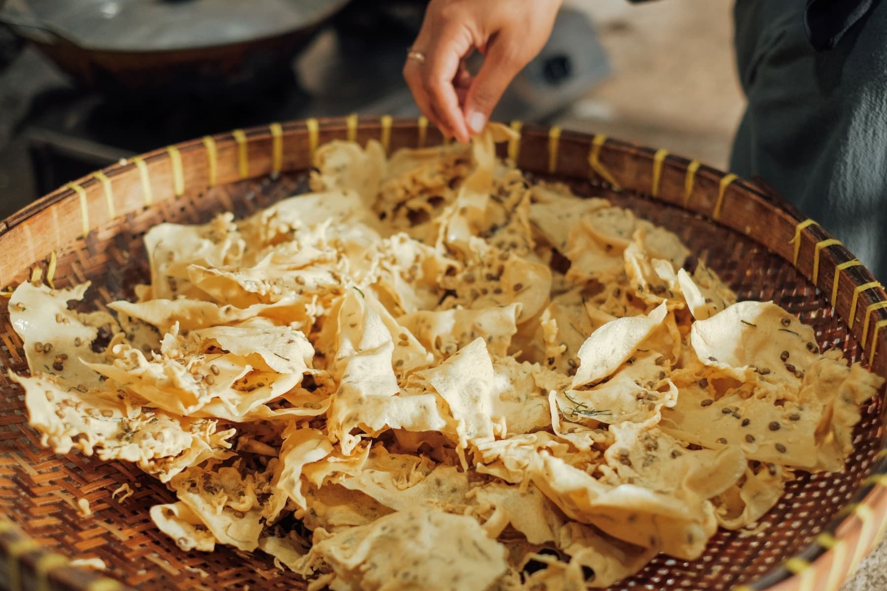 Foto beberapa lempengan rempeyek berada di atas tampah setelah digoreng.